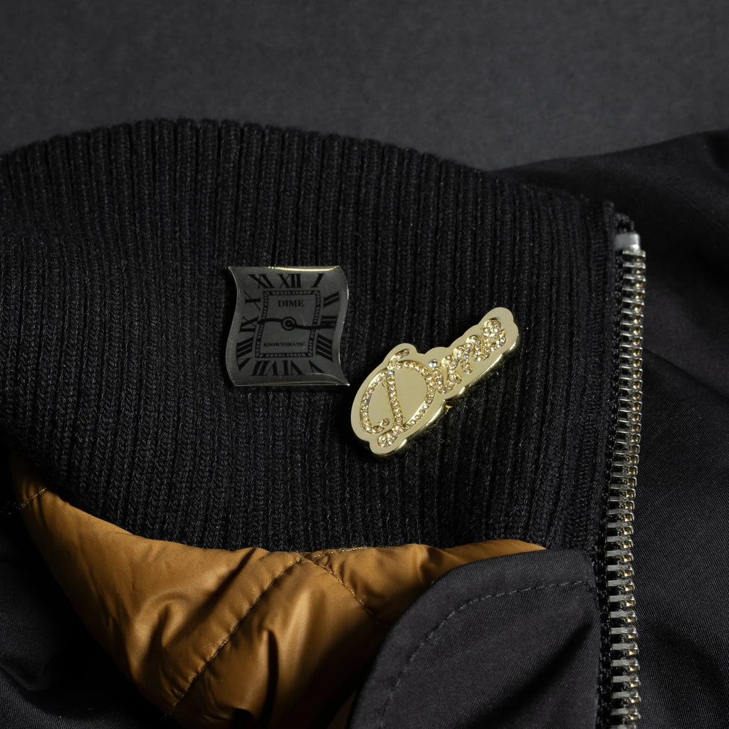 Pin Pack Dime MTL – pins argent et doré pour veste, sac ou casquette, disponibles chez Yagö Skateshop Mons. Vue sur veste
