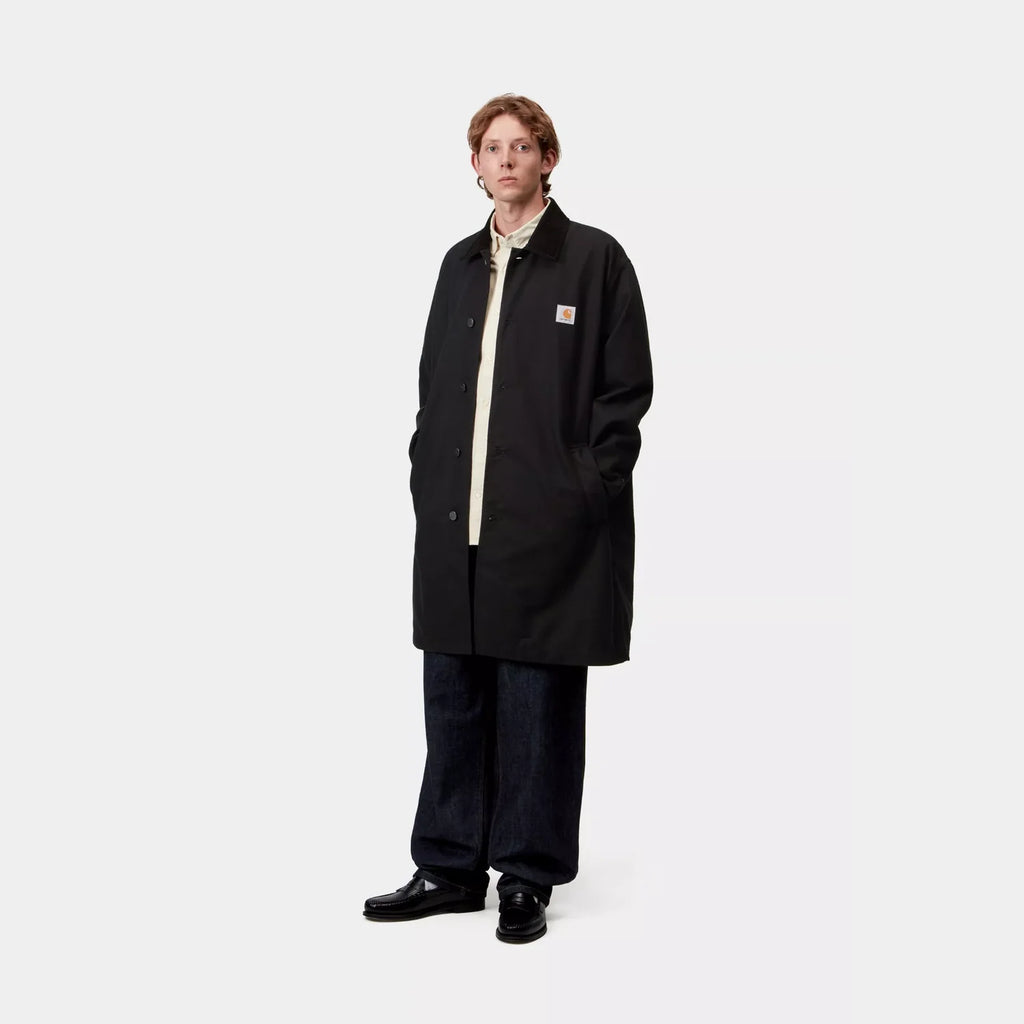 Carhartt WIP manteau Webster Black coton doublé col velours côtelé Square Label – skateshop Mons. Vu de face porté par un mannequin