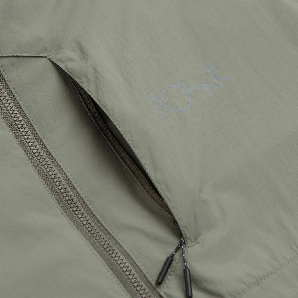 Veste Polar Skate Co. Kodak Insulated Vetiver en nylon ripstop avec isolation Primaloft Black 100 g, capuche ajustable et logo 3M – dispo à Mons. Vue sur le zip poitrine