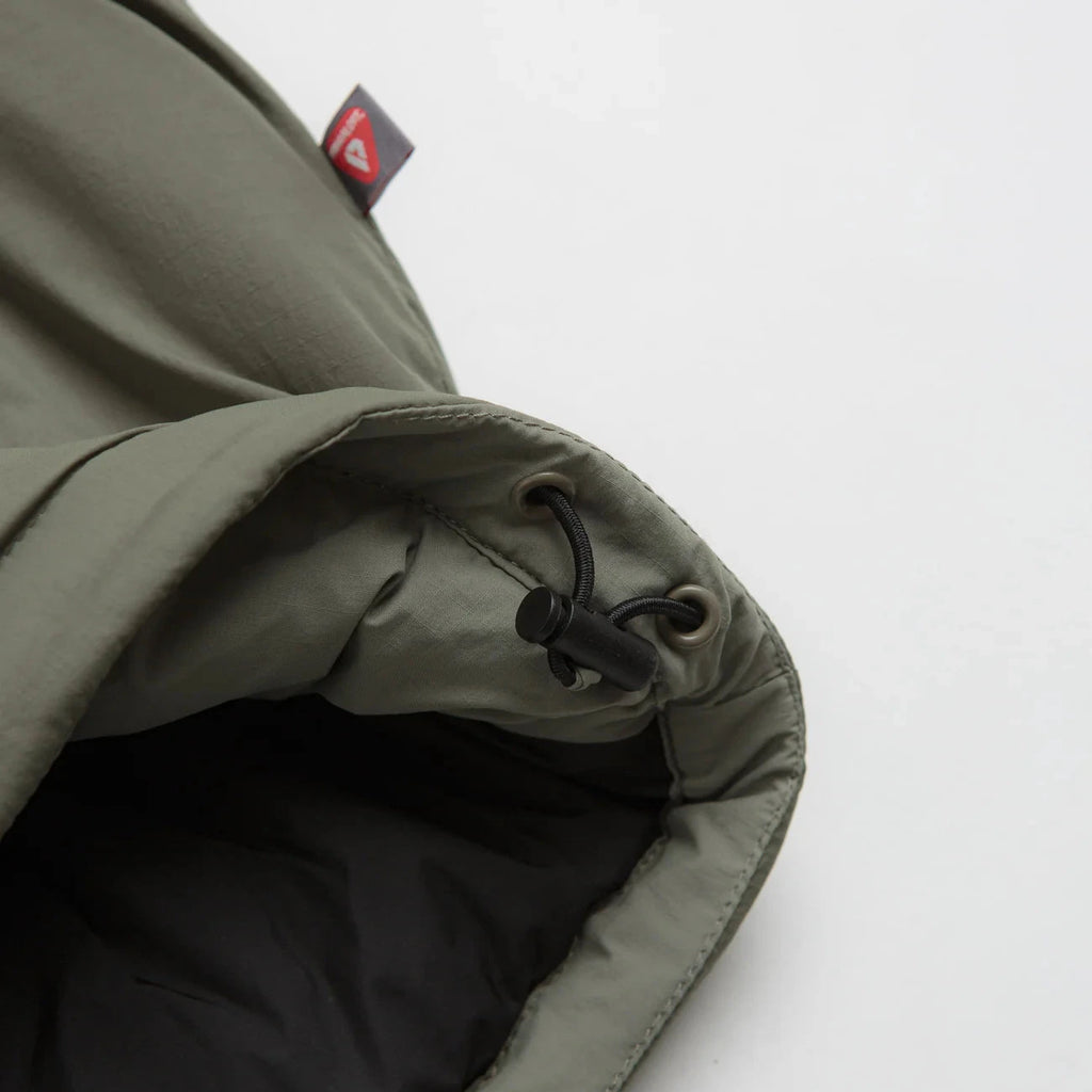 Veste Polar Skate Co. Kodak Insulated Vetiver en nylon ripstop avec isolation Primaloft Black 100 g, capuche ajustable et logo 3M – dispo à Mons. Vue sur le cordon de serrage de la taille