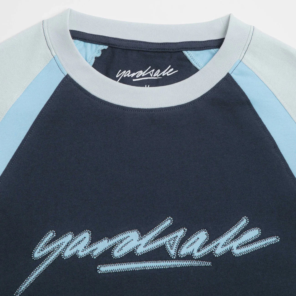 T-shirt skate Yardsale Daze Bleu en coton avec manches raglan et logo brodé – disponible à Mons chez Yagö Skateshop. Zoom sur le col